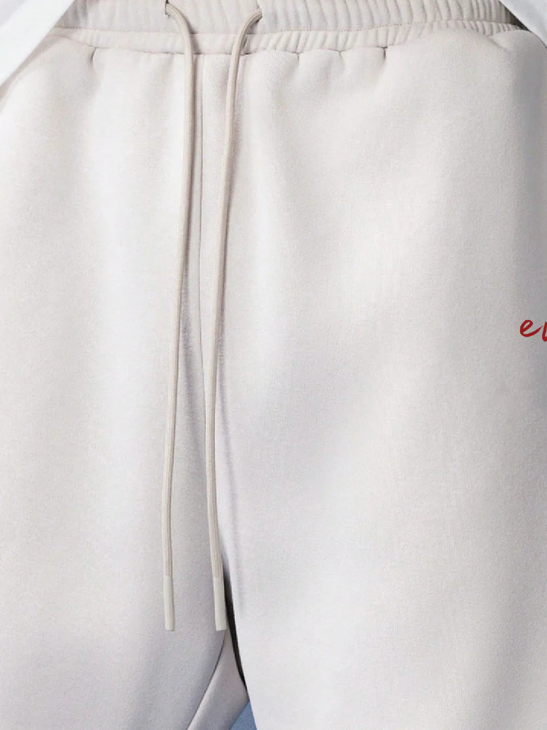 Person wearing white shorts with a brand logo 