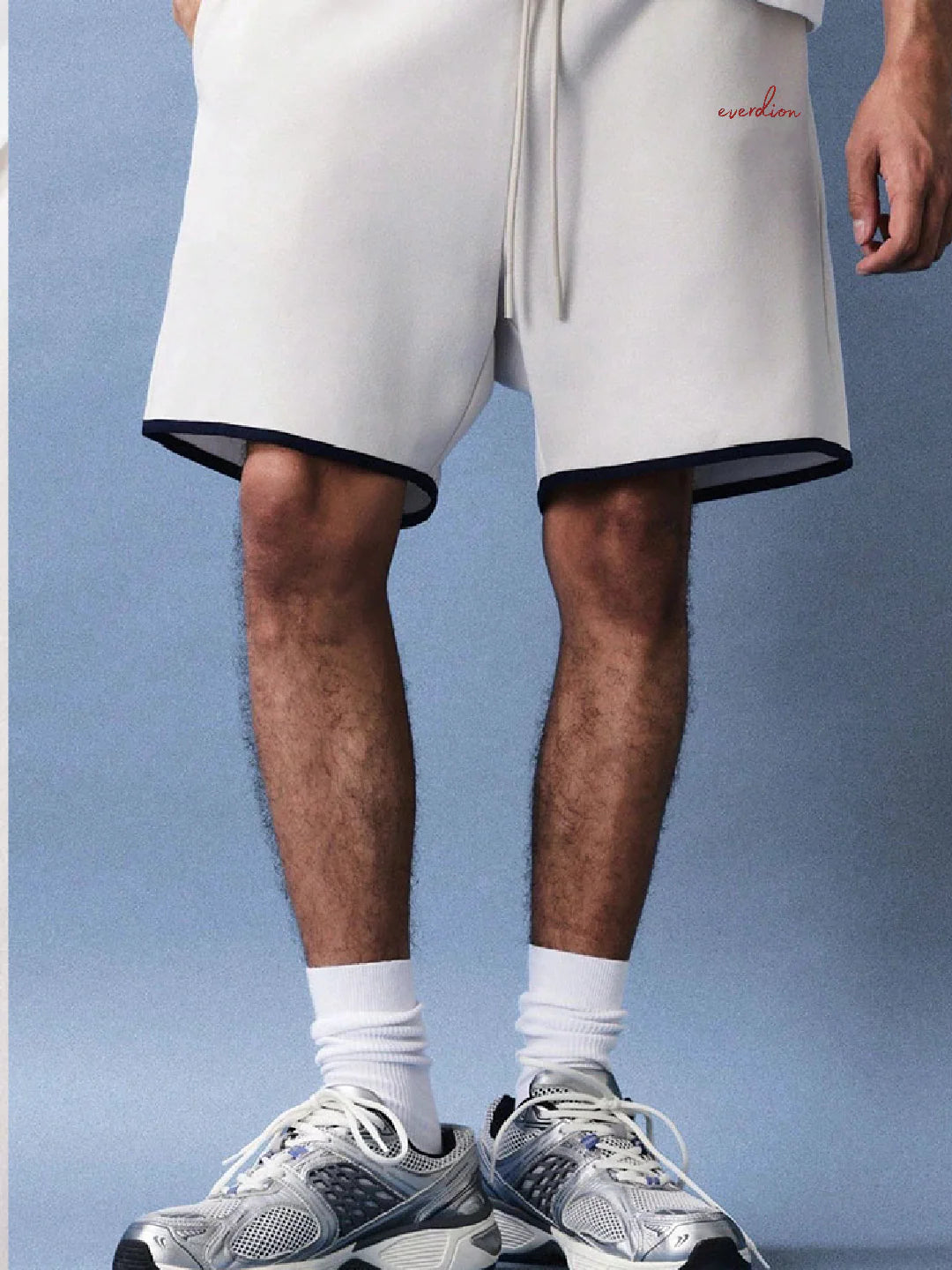 Person wearing white shorts with a brand logo 