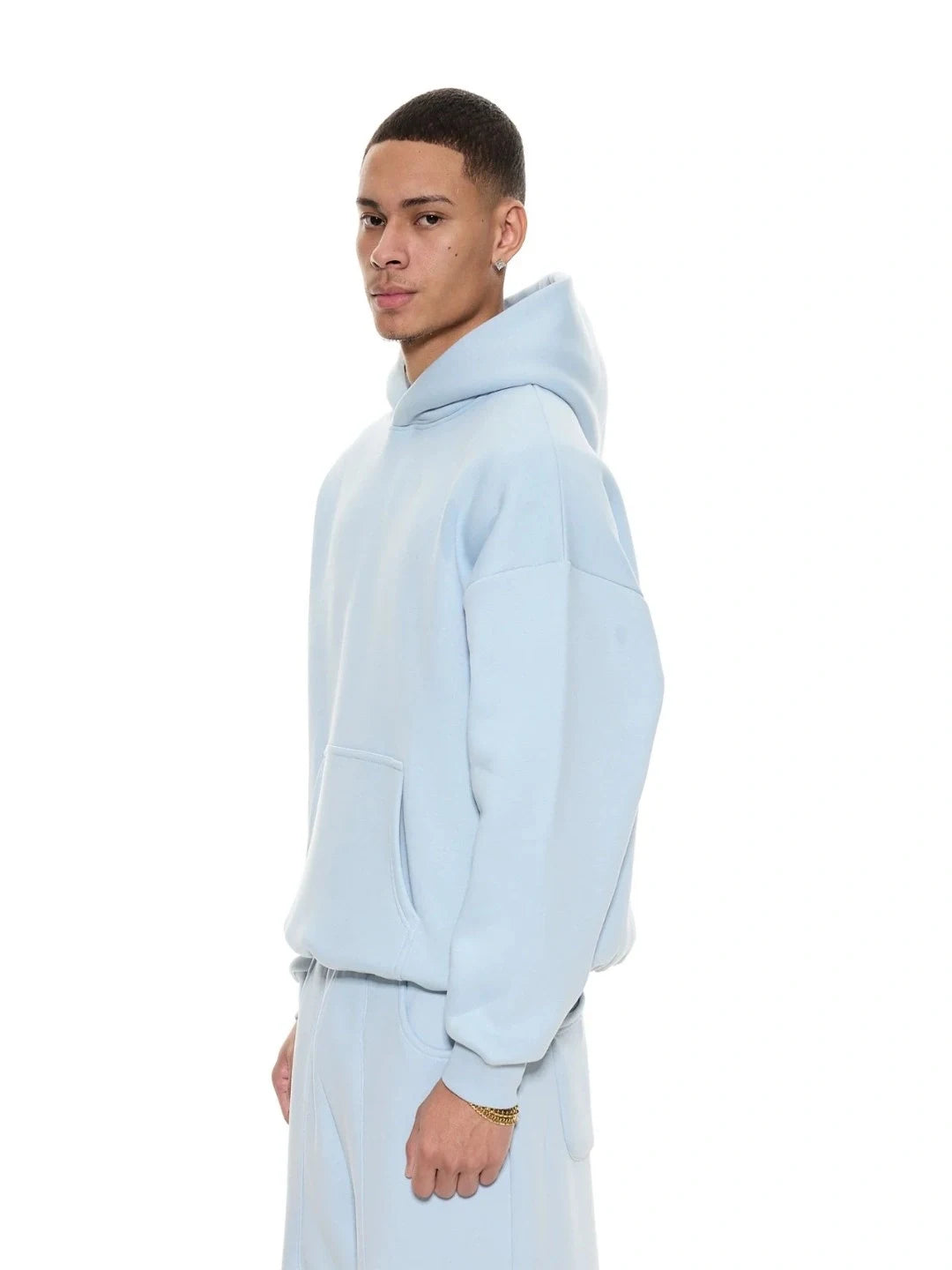 Person wearing a light blue hoodie and pants on a white background
