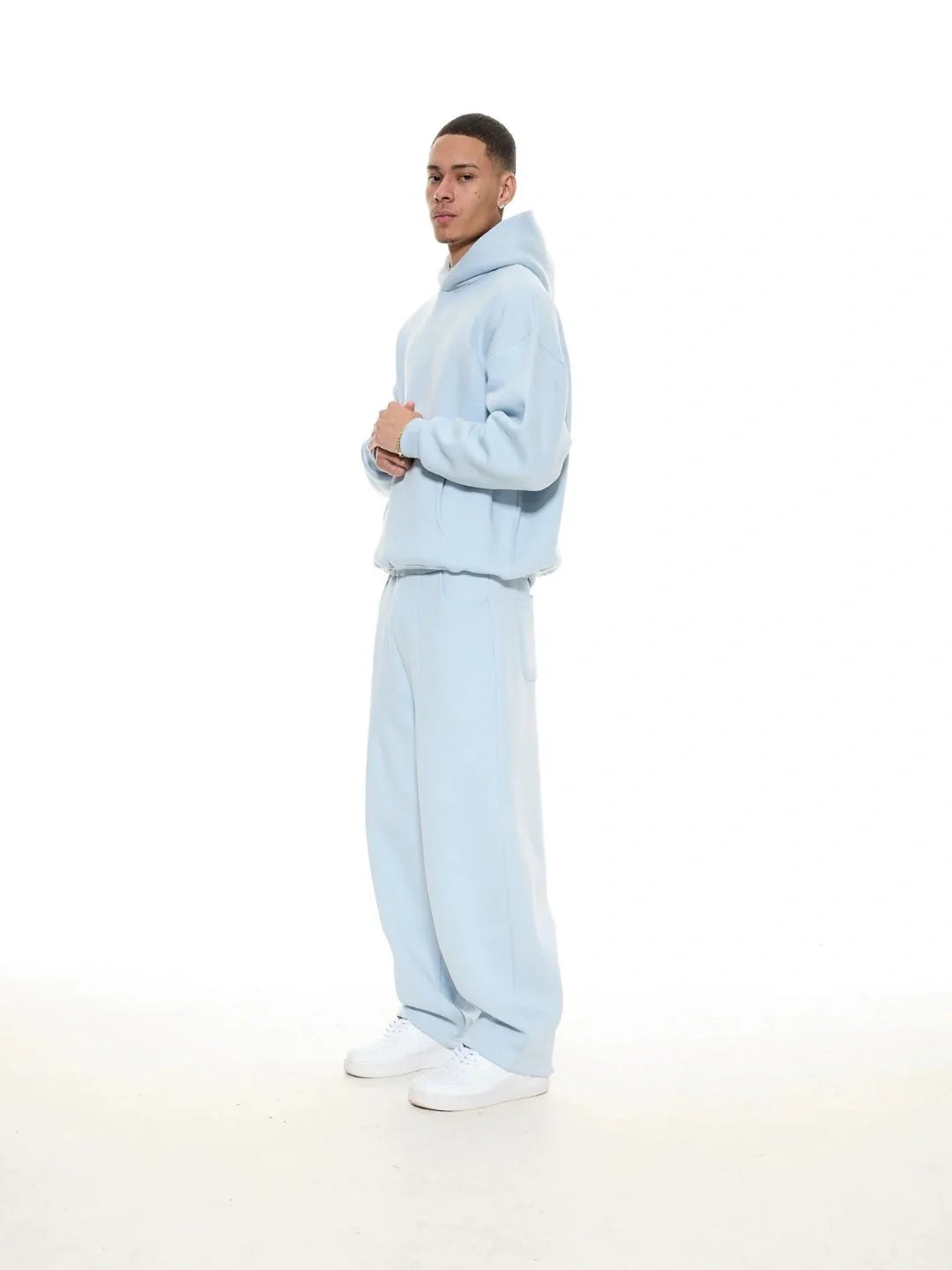 Person wearing a light blue tracksuit on a white background