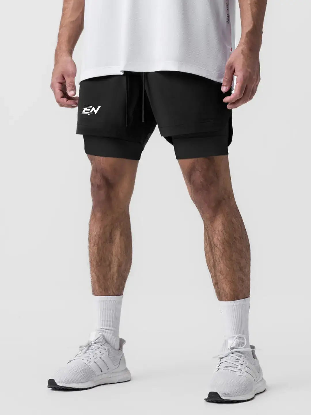 2-in-1 black shorts with inner compression media pockets, outer front pockets, a back zip pocket and a utility loop for training essentials.