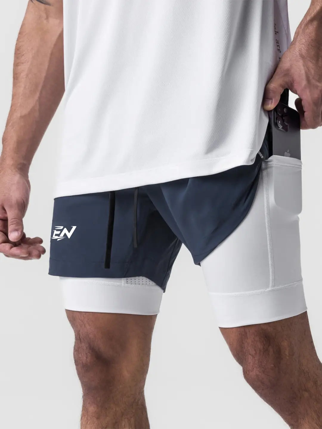 2-in-1 navy shorts with inner compression media pockets, outer front pockets, a back zip pocket and a utility loop for training essentials.