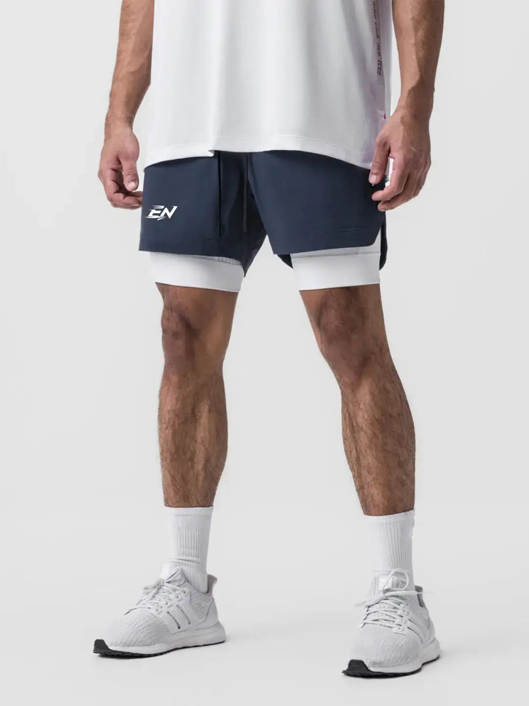 2-in-1 navy shorts with inner compression media pockets, outer front pockets, a back zip pocket and a utility loop for training essentials.