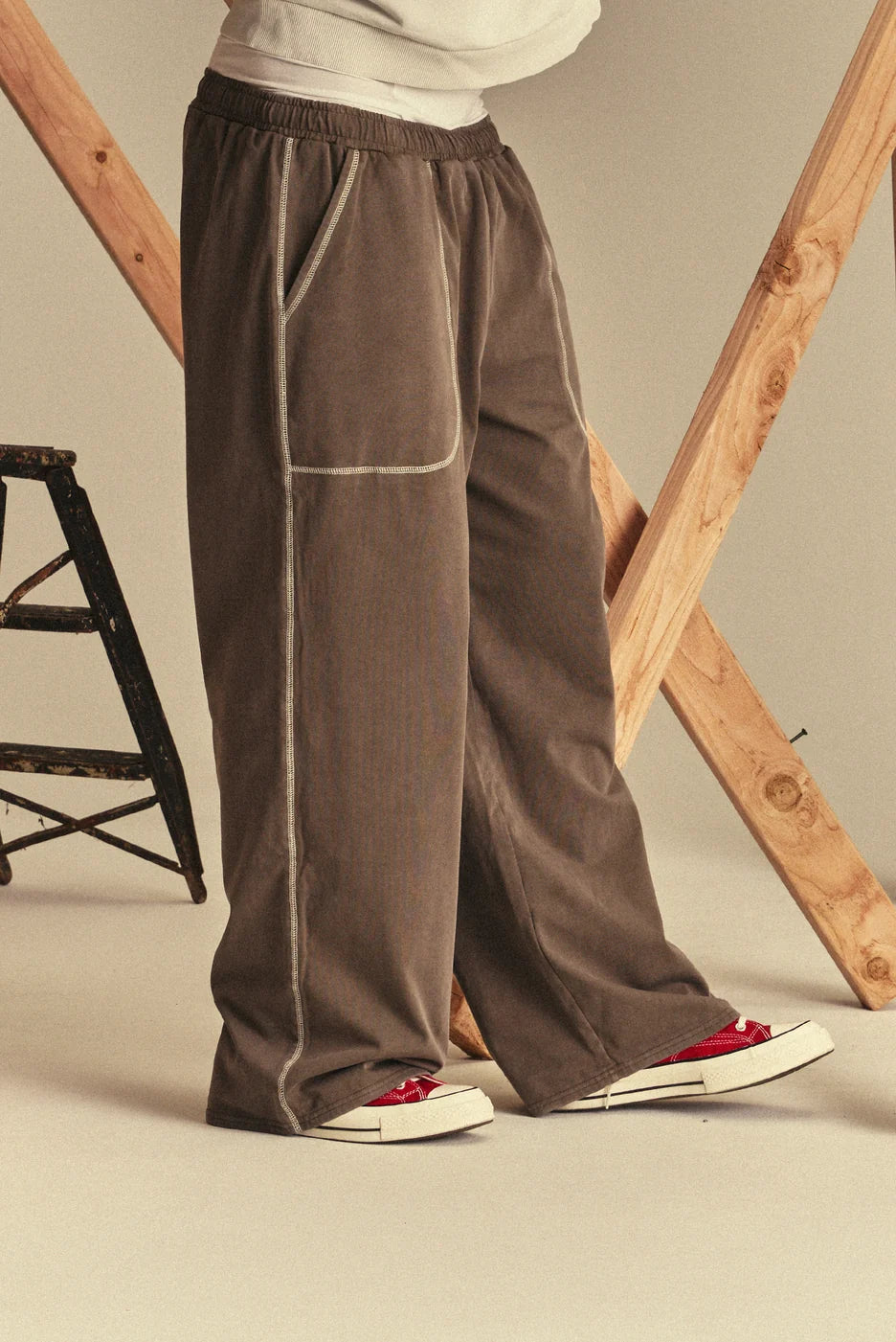 Brown sweatpants worn by a person with a neutral background