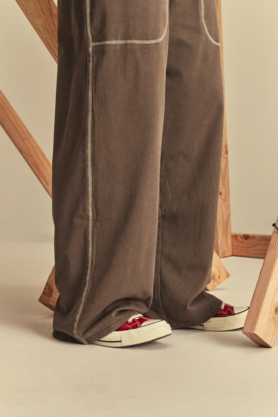 Brown sweatpants with white trim worn by a person
