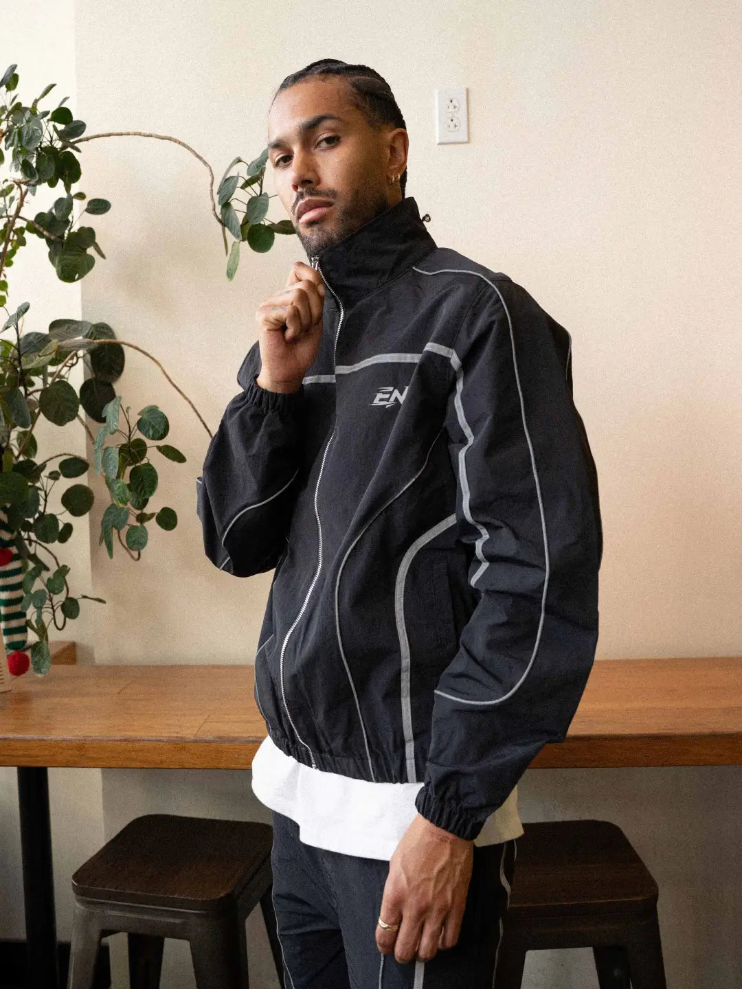 The Black jacket delivers a structured yet lightweight feel, while the relaxed-fit track pants ensure fluid movement and all-day comfort. 