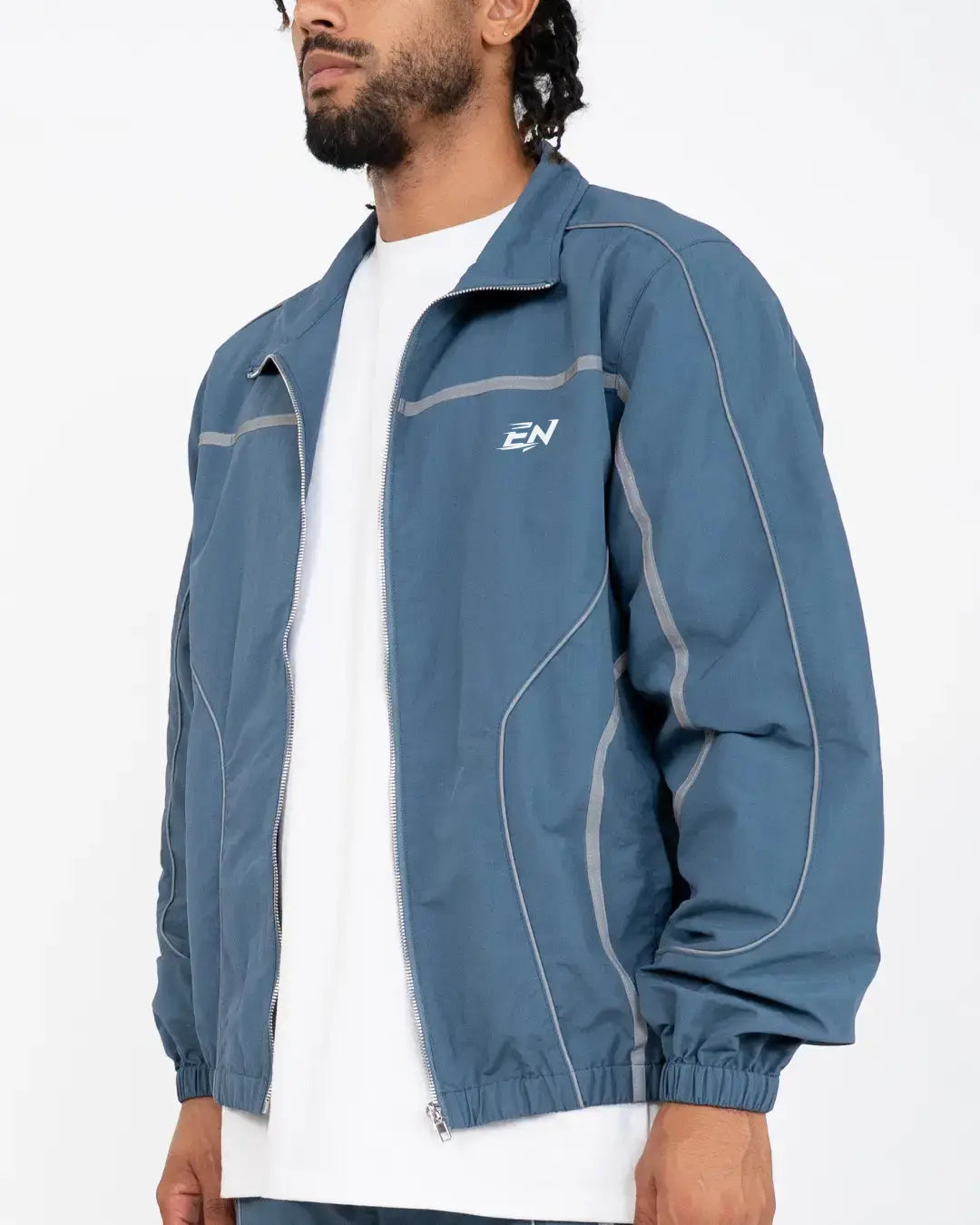 The Blue jacket delivers a structured yet lightweight feel, while the relaxed-fit track pants ensure fluid movement and all-day comfort. 