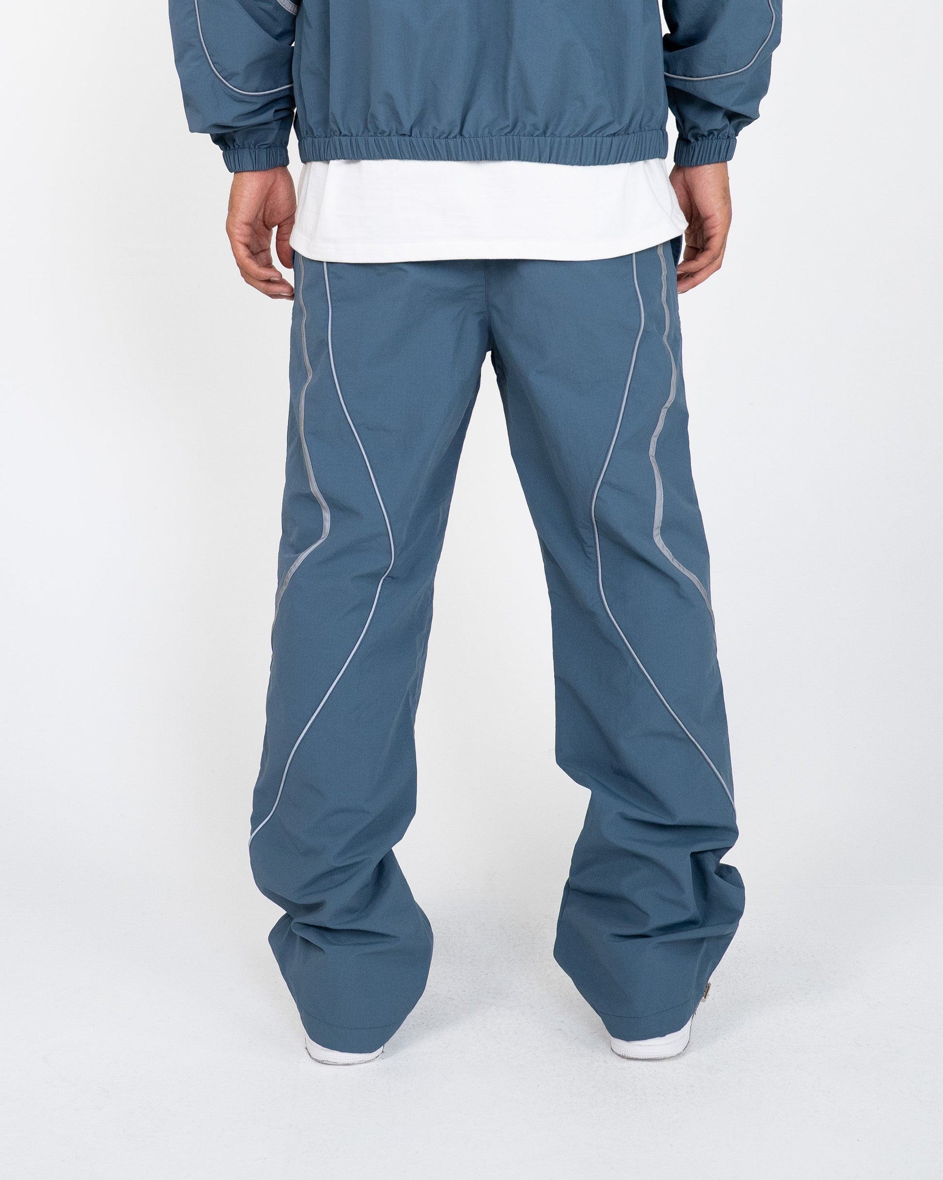 The Blue pant delivers a structured yet lightweight feel, while the relaxed-fit track pants ensure fluid movement and all-day comfort. 