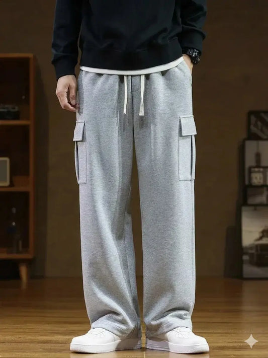 Person wearing grey cargo pants with a blurred indoor background.