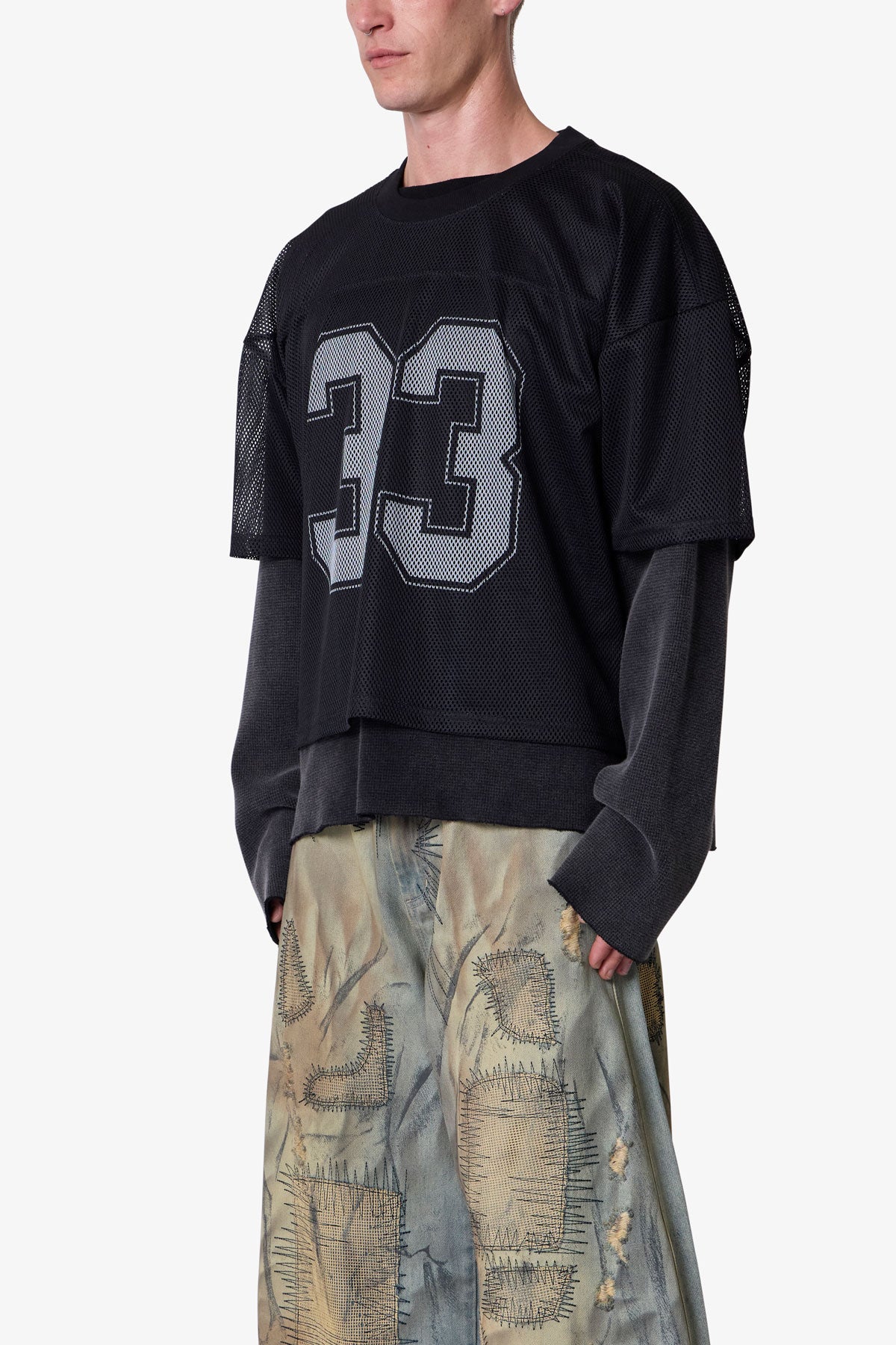 Person wearing a black sweatshirt with the number 33 on a white background