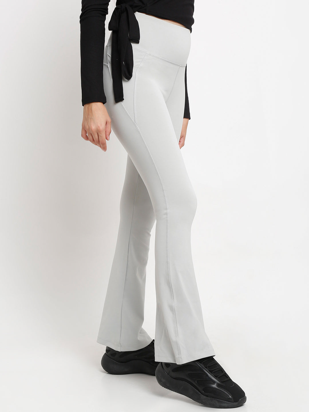 A pair of high-waisted grey flare pants with pockets, in a bootcut style.