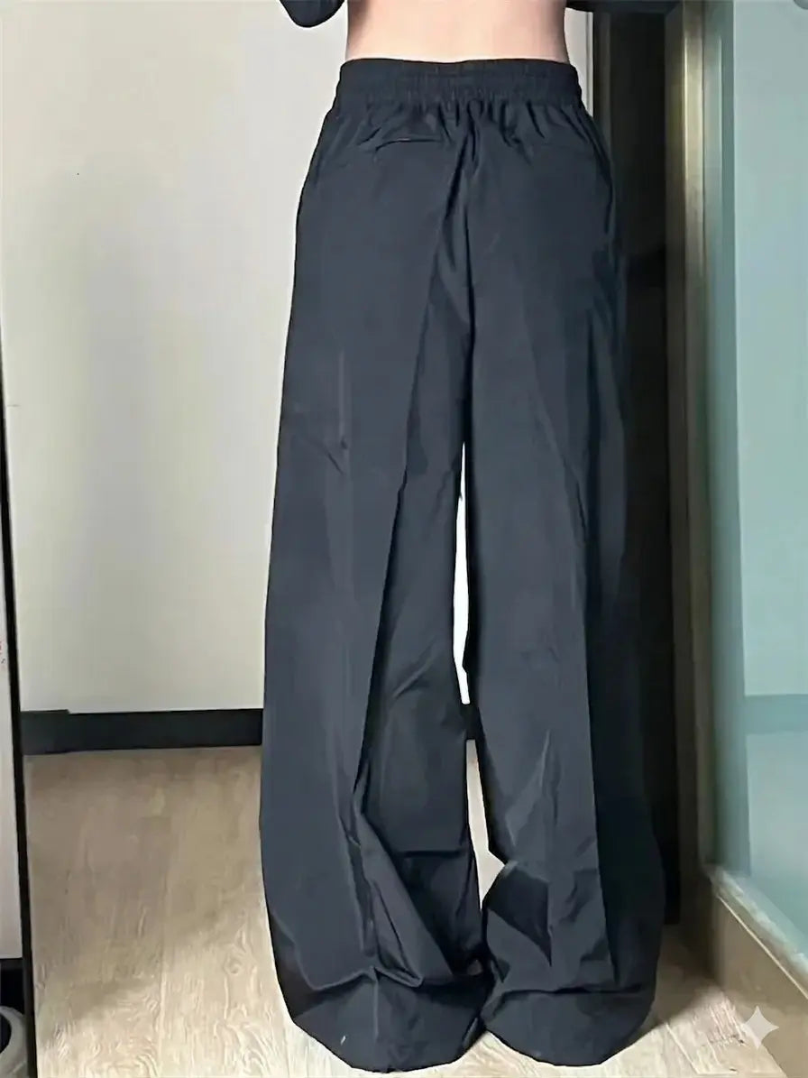 Black wide-leg pants being worn indoors with a neutral background