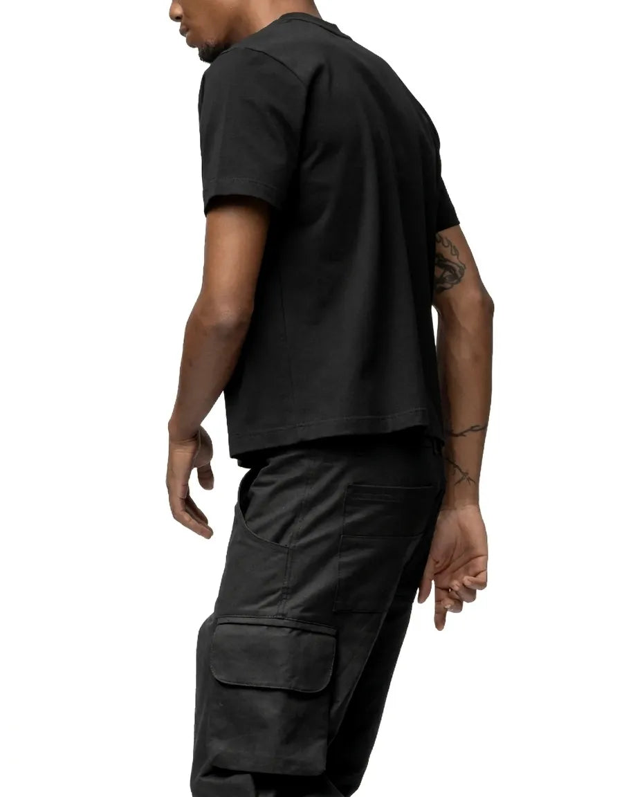 Person wearing a black t-shirt and cargo pants on a white background