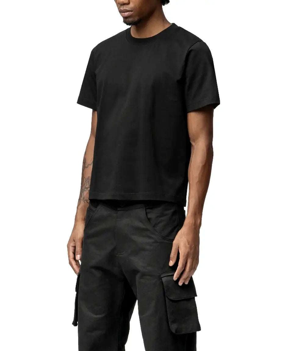 Person wearing a black t-shirt and cargo pants on a white background