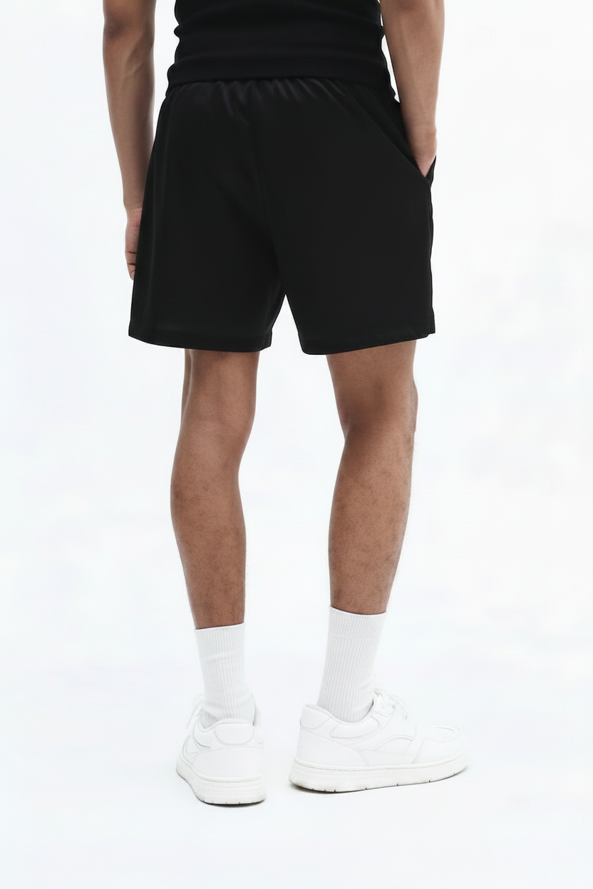 Person wearing black shorts and white socks on a white background