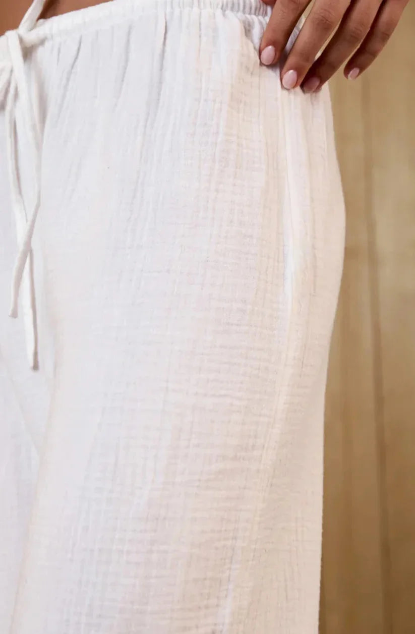 Close-up of white textured pants with a beige background