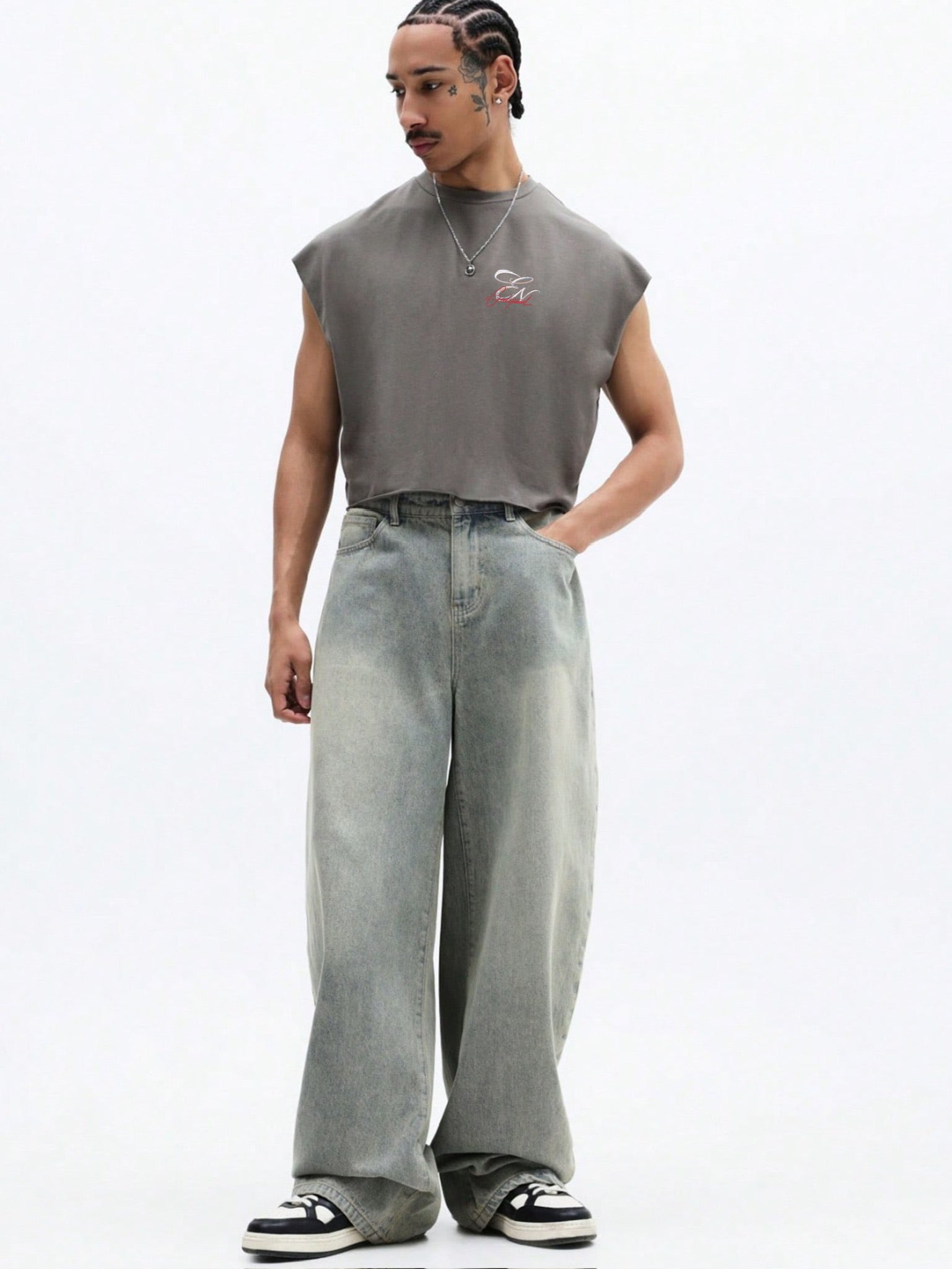 Person wearing a sleeveless grey top and light blue jeans on a white background