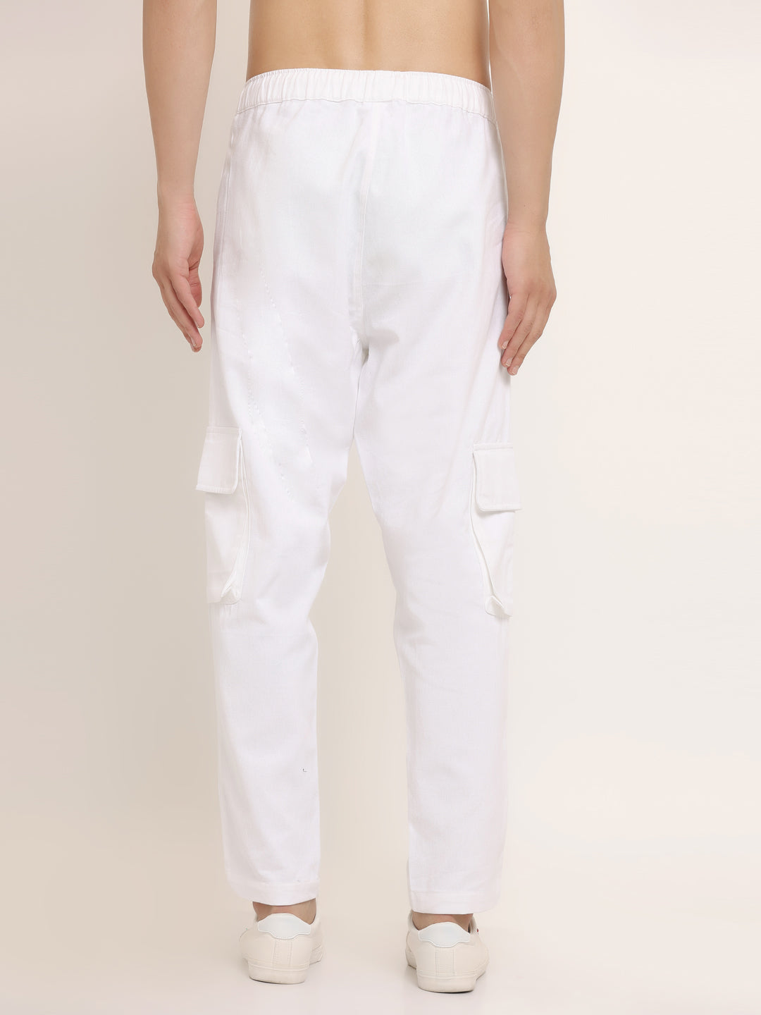A white slim-fit cargo pants with multiple pockets, featuring an elasticated waistband with a drawstring.