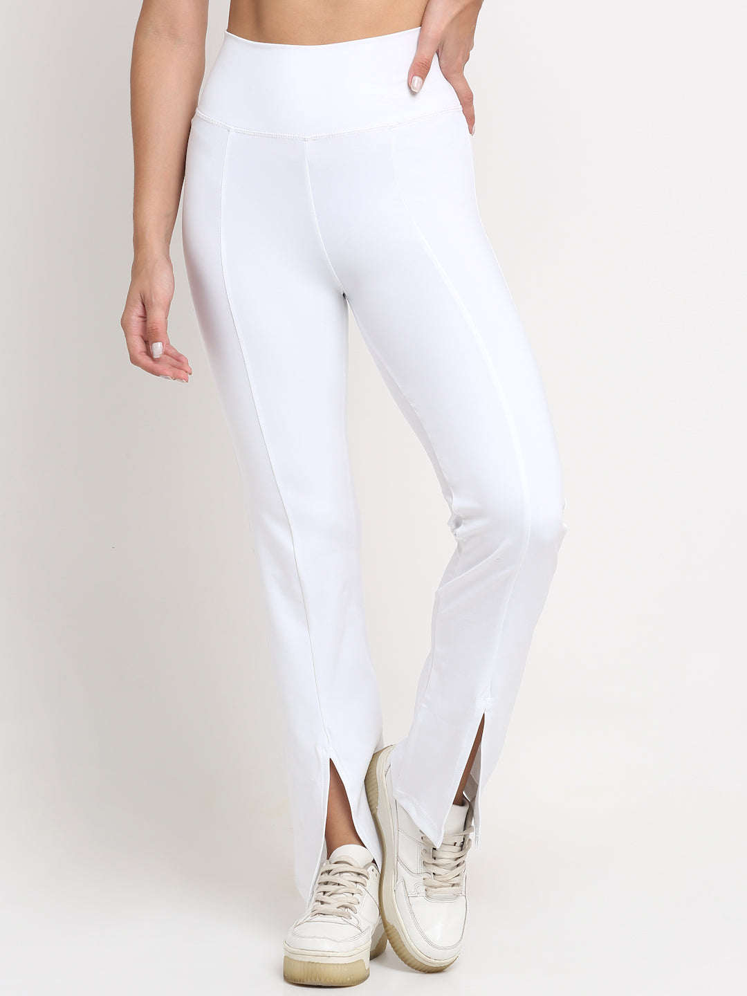 High-waisted White yoga pants with a front slit, featuring a skinny waistband and elevated front seams. The pants are designed with a flared 