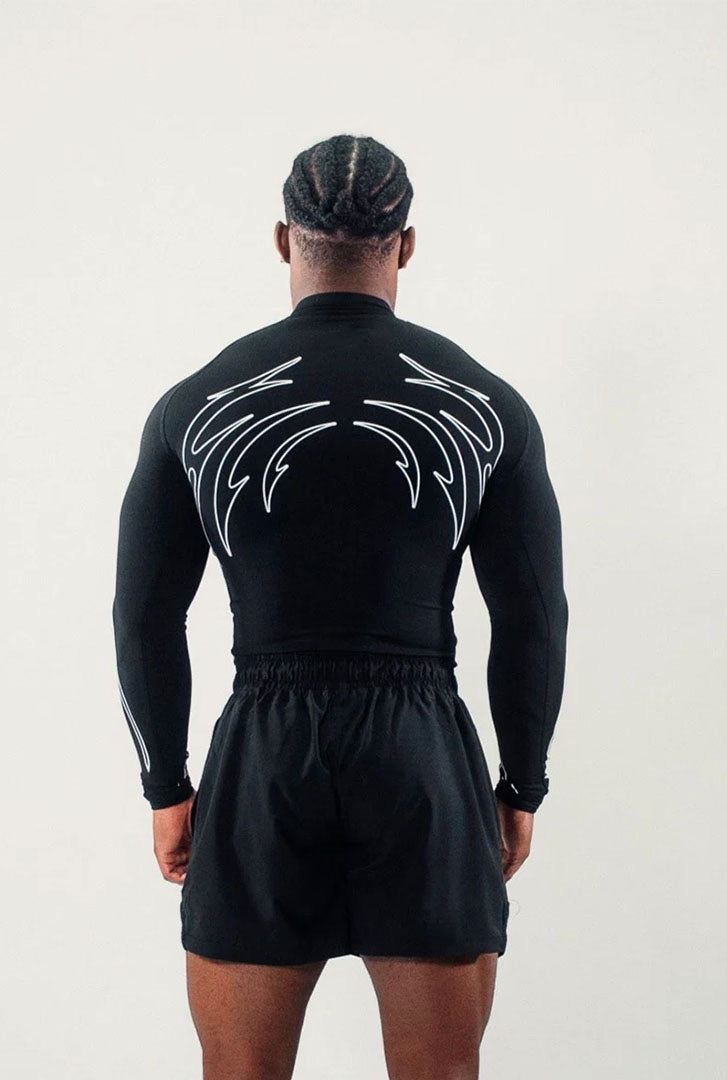 Person wearing a black athletic outfit with white designs on a plain background