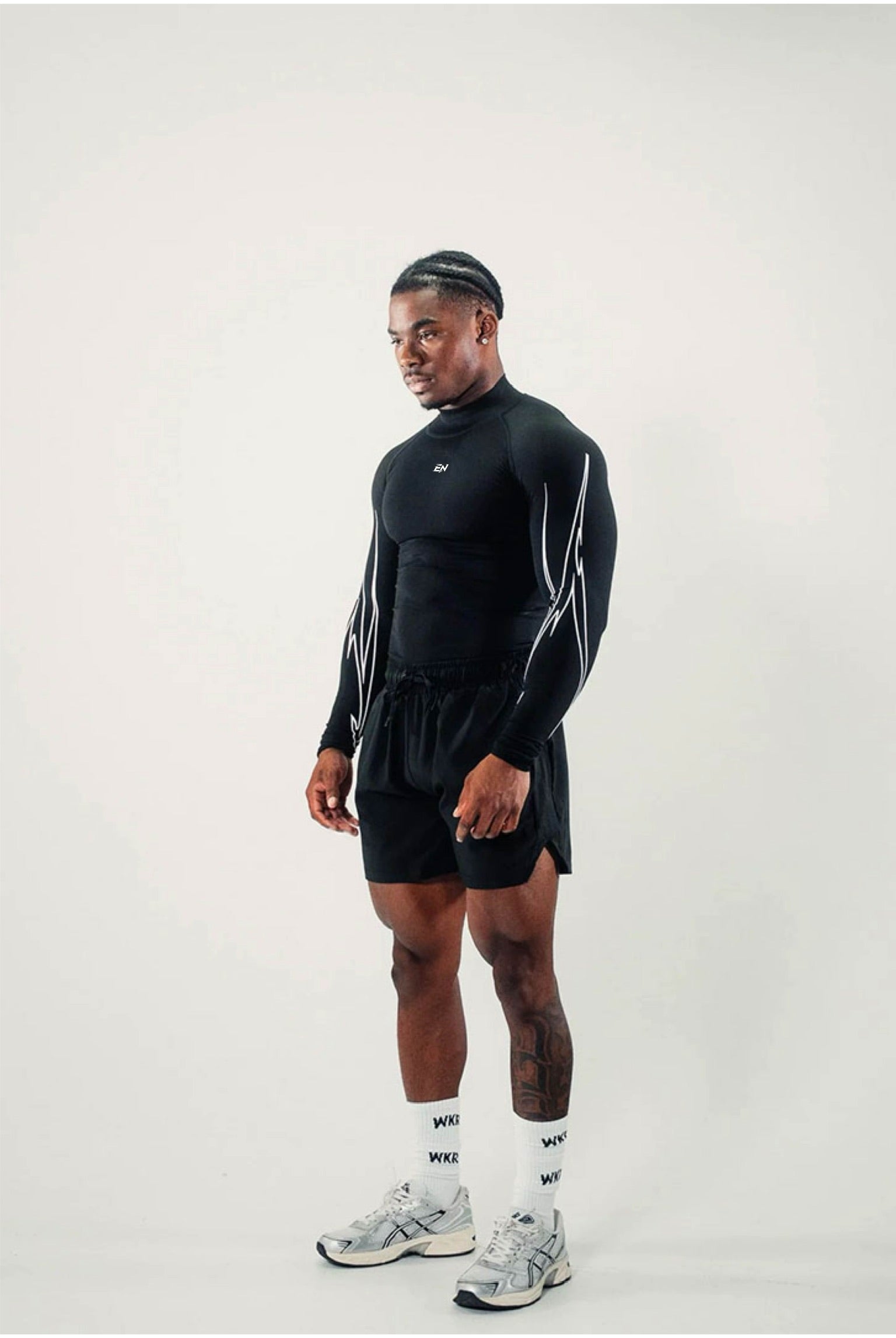 Person wearing a black athletic outfit with white accents on a plain background