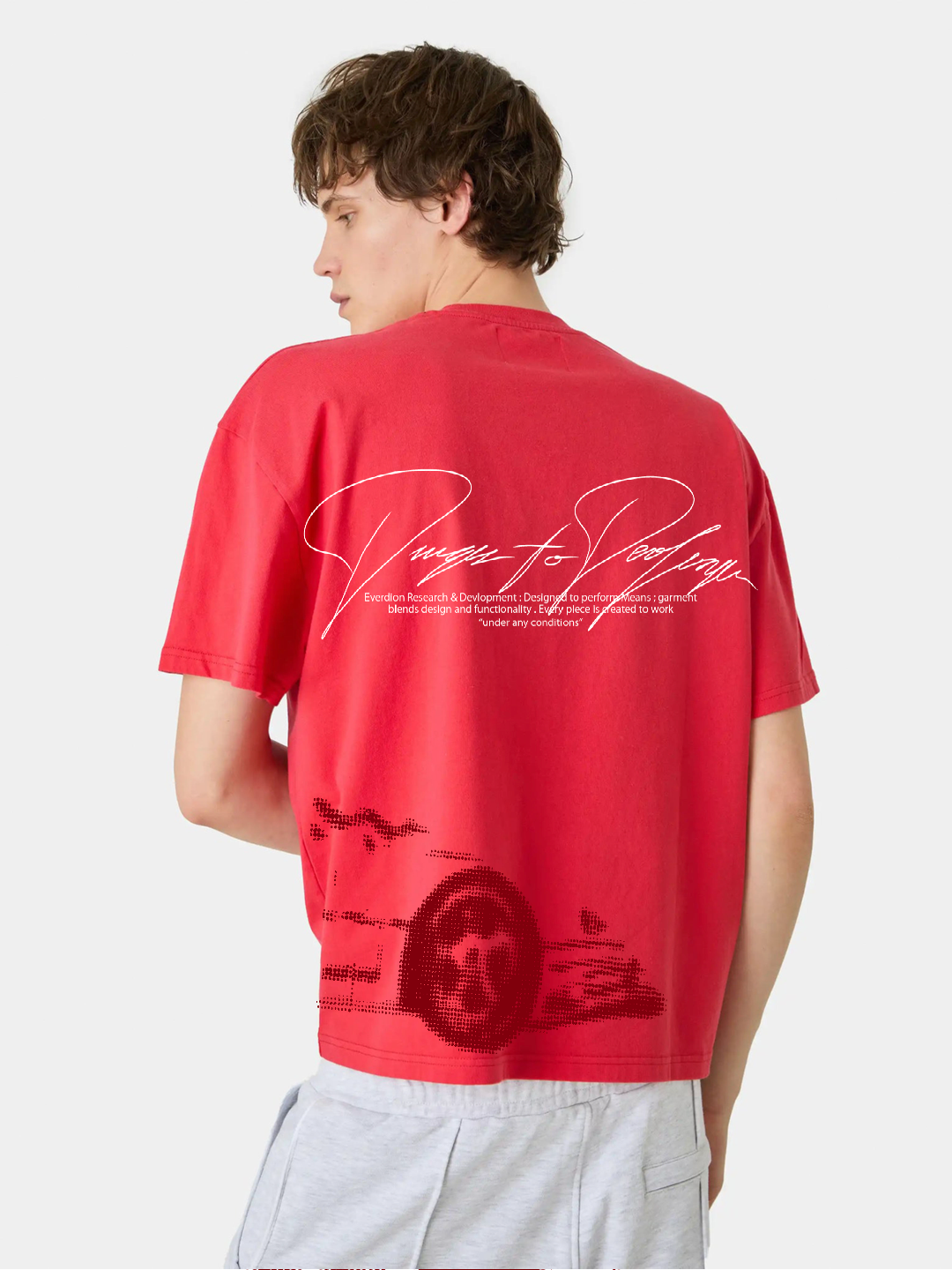 Person wearing a red t-shirt with text and graphics on the back, standing against a white background