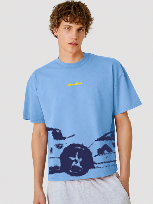Person wearing a blue t-shirt with a graphic design on a plain background