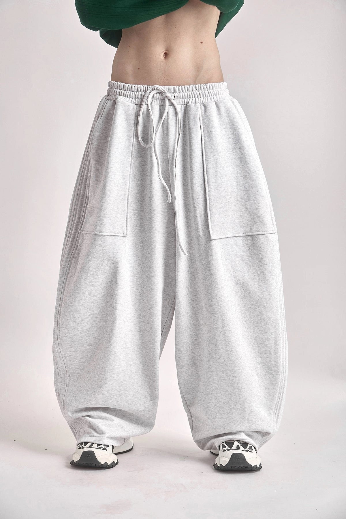 Light grey sweatpants worn by a person on a plain background