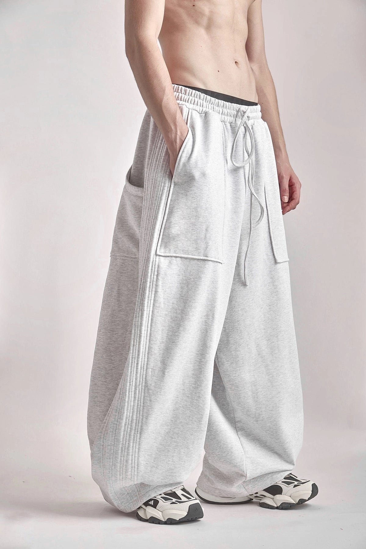 Person wearing light grey wide-leg pants on a plain background
