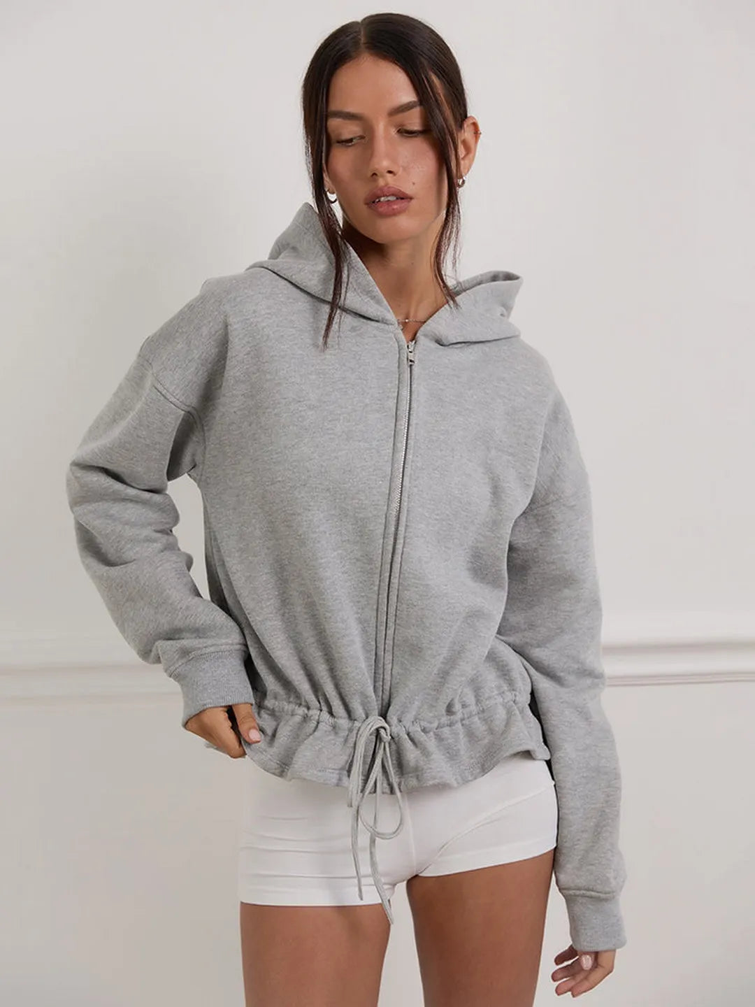 Woman wearing a gray hoodie with a white background