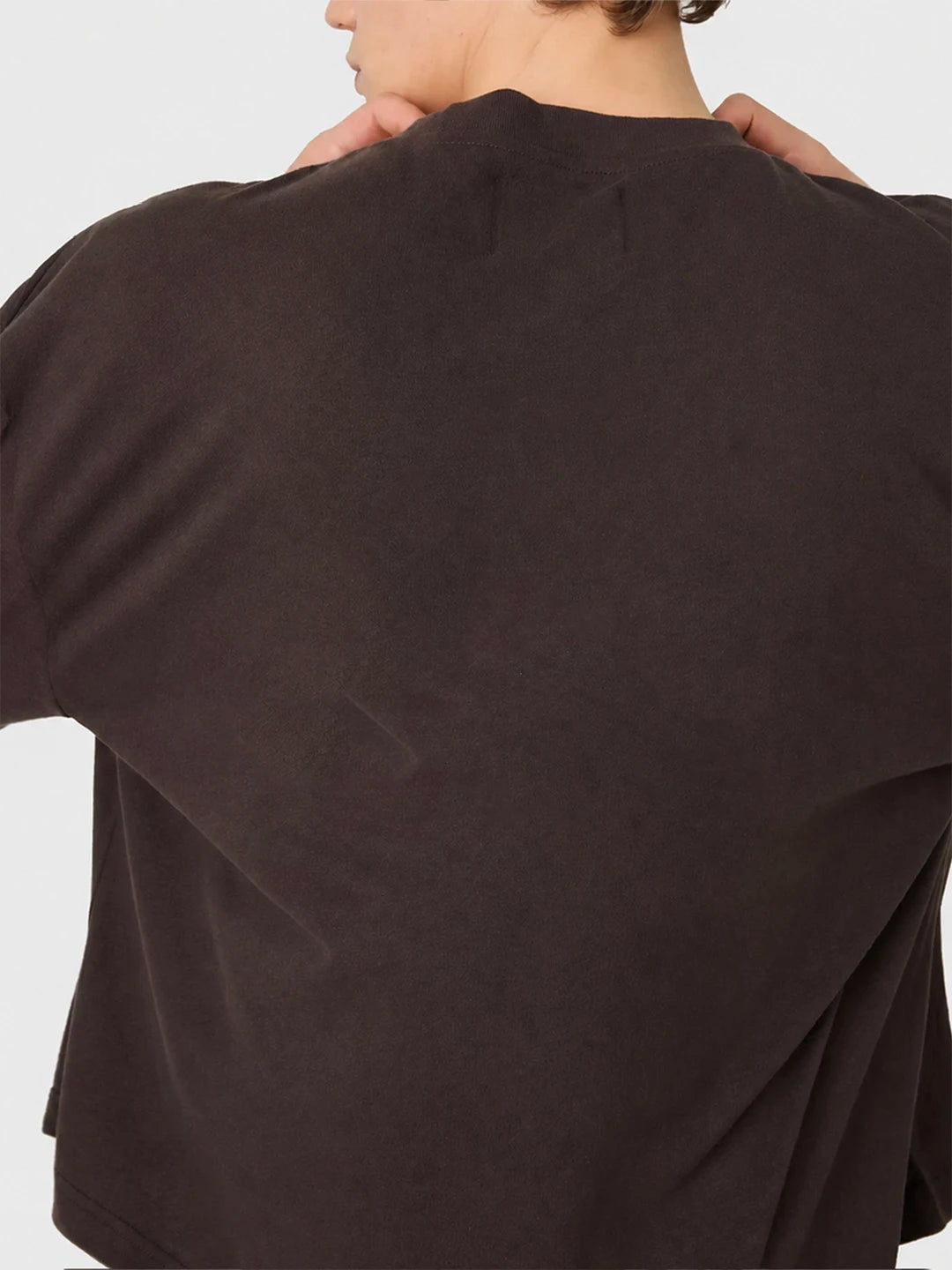 Brown sweater worn by a person on a light grey background