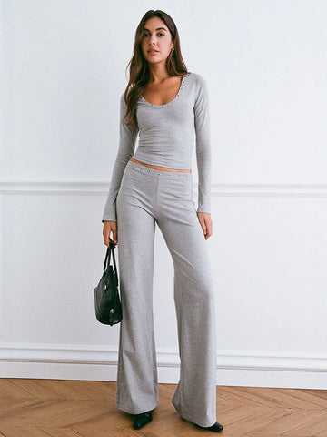 Woman wearing a gray outfit with a white wall background