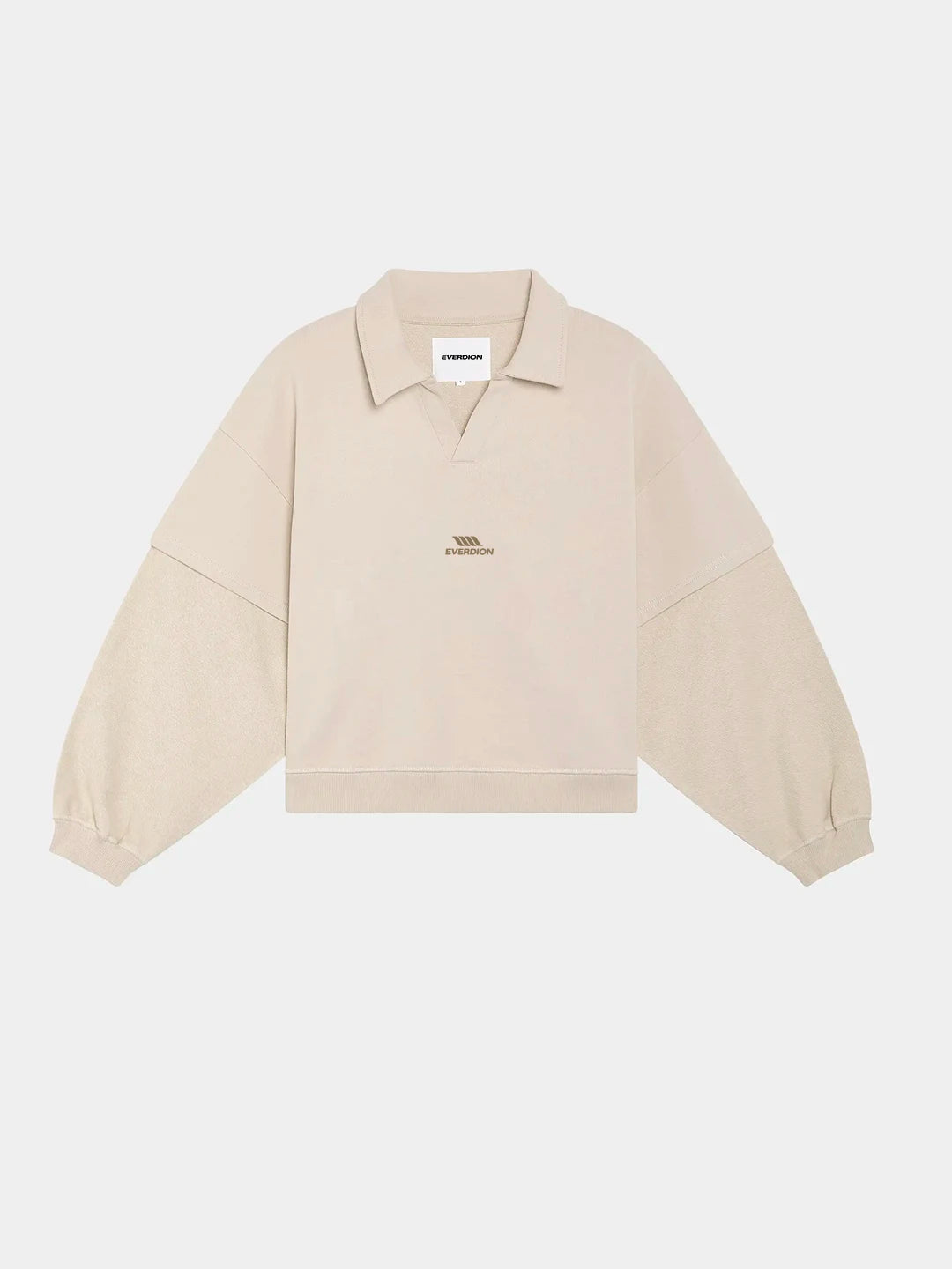 A light beige cropped polo t-shirt with a polo collar and long sleeves, featuring a small embroidered logo on the left chest