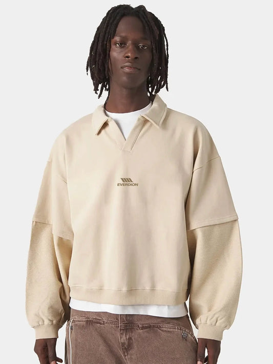 A model wearing a beige polo t-shirt with a collar and a small 'EVERDION' logo on the chest, layered over a white t-shirt and brown corduroy pants