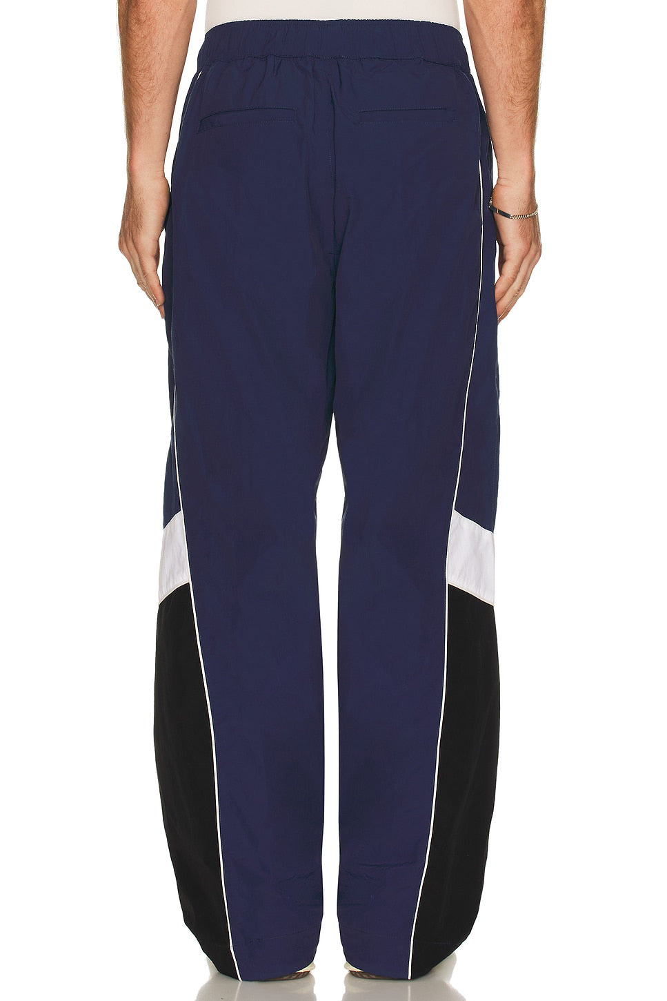 Navy blue pants with white and black side panels on a white background