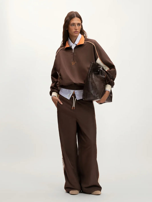 Person wearing a brown outfit with a jacket and pants on a white background