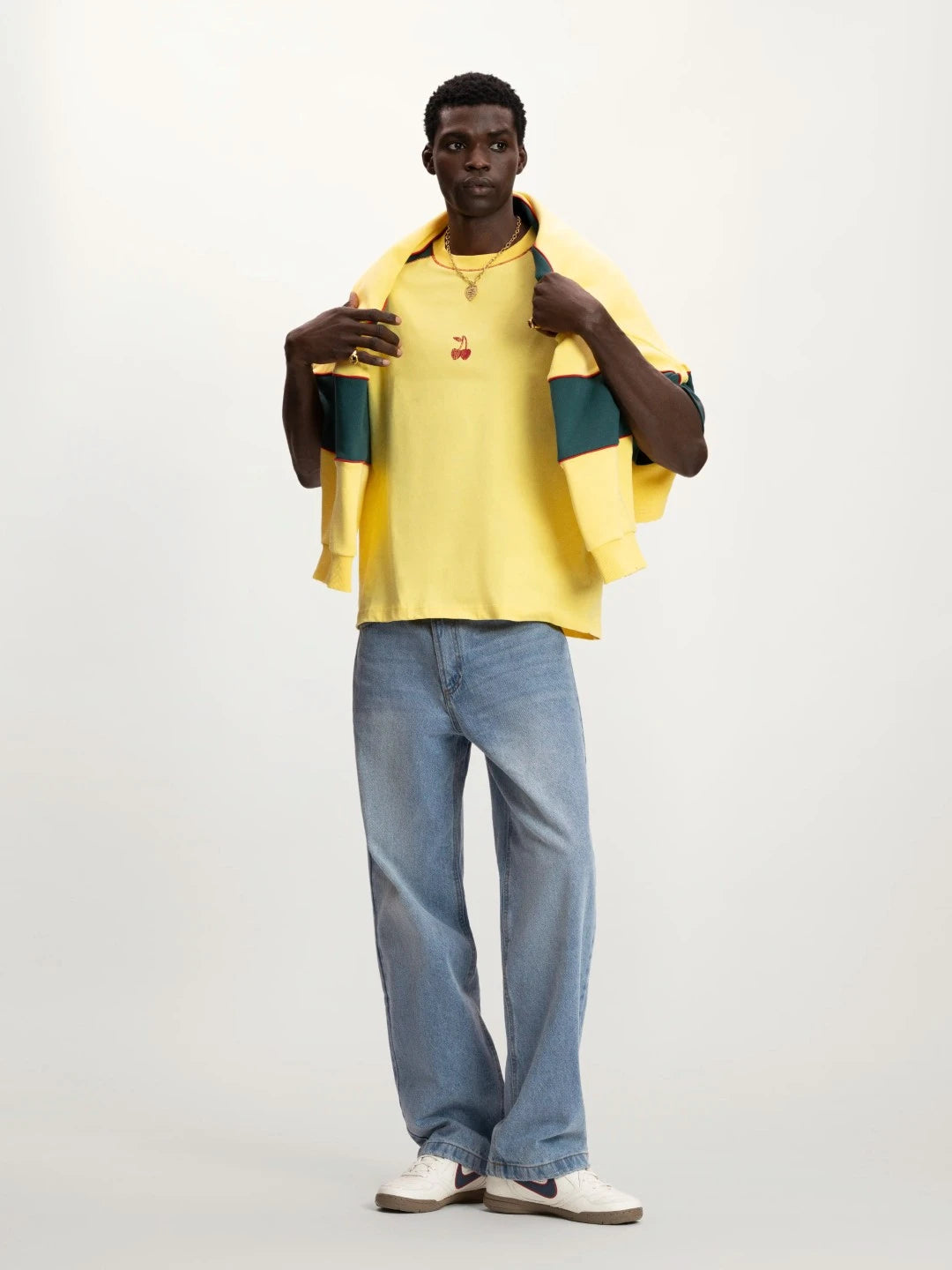 Person wearing a yellow shirt and blue jeans on a white background