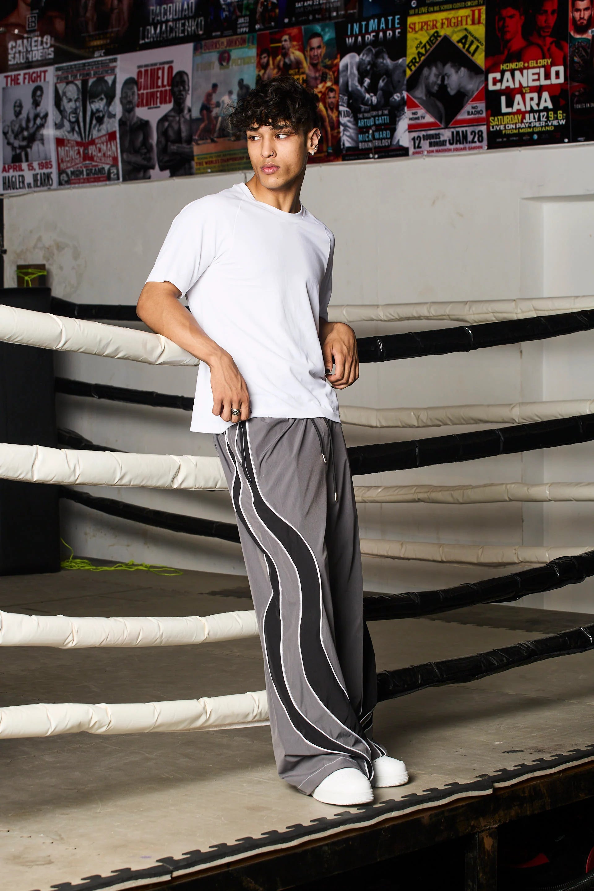 Person wearing grey track pants with black stripes 