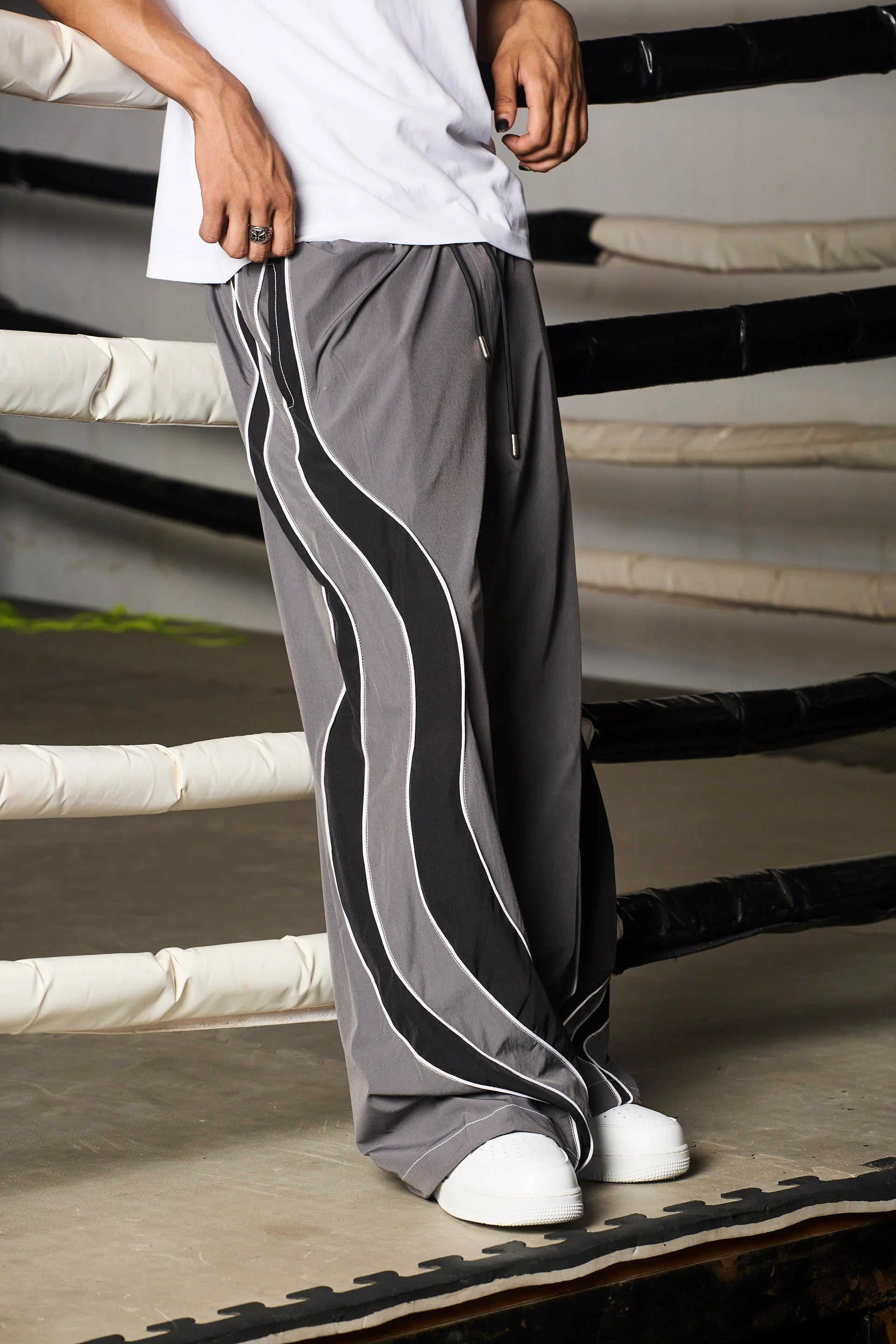 Person wearing grey track pants with black stripes 
