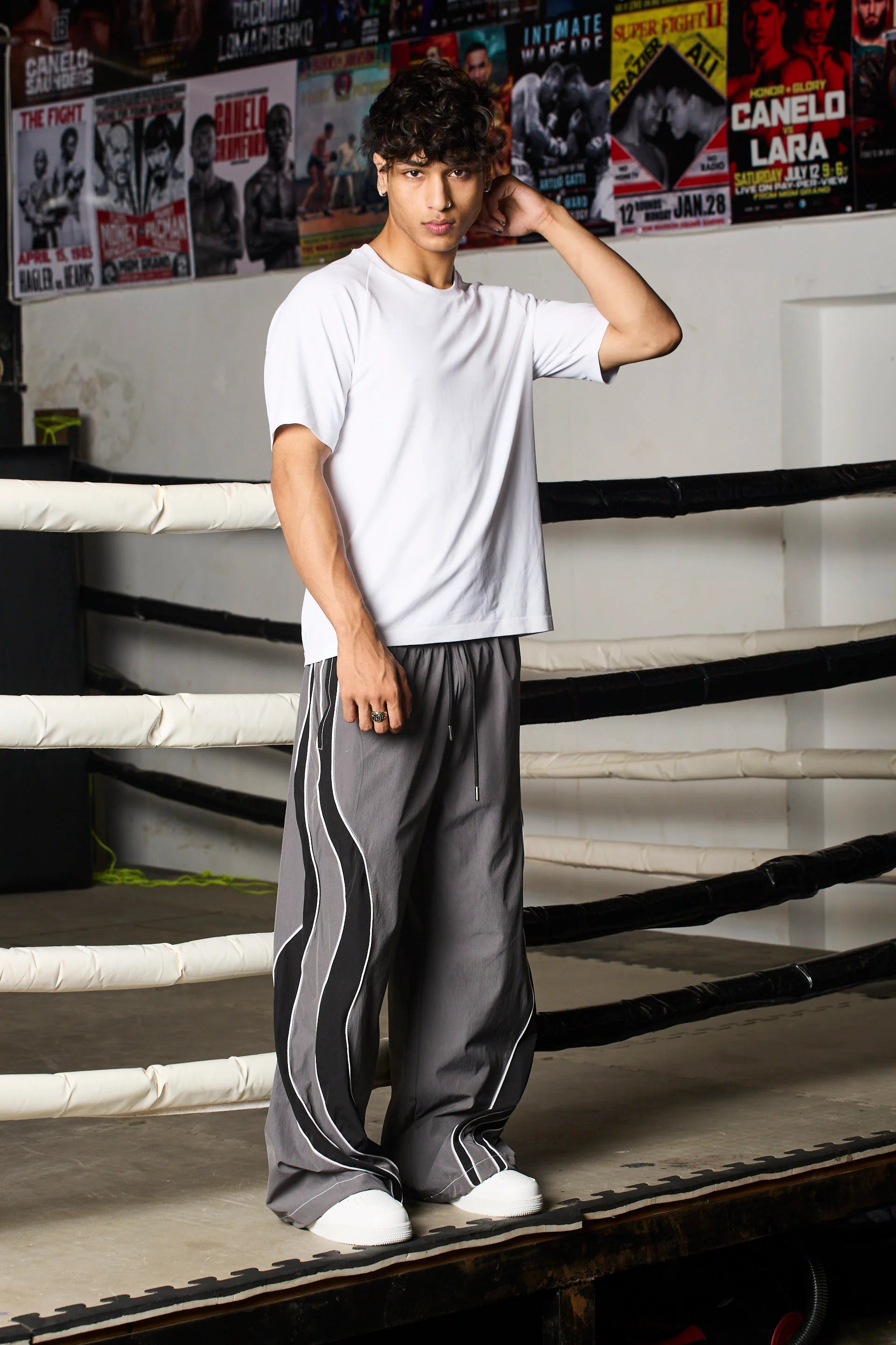 Person wearing grey track pants with black stripes 