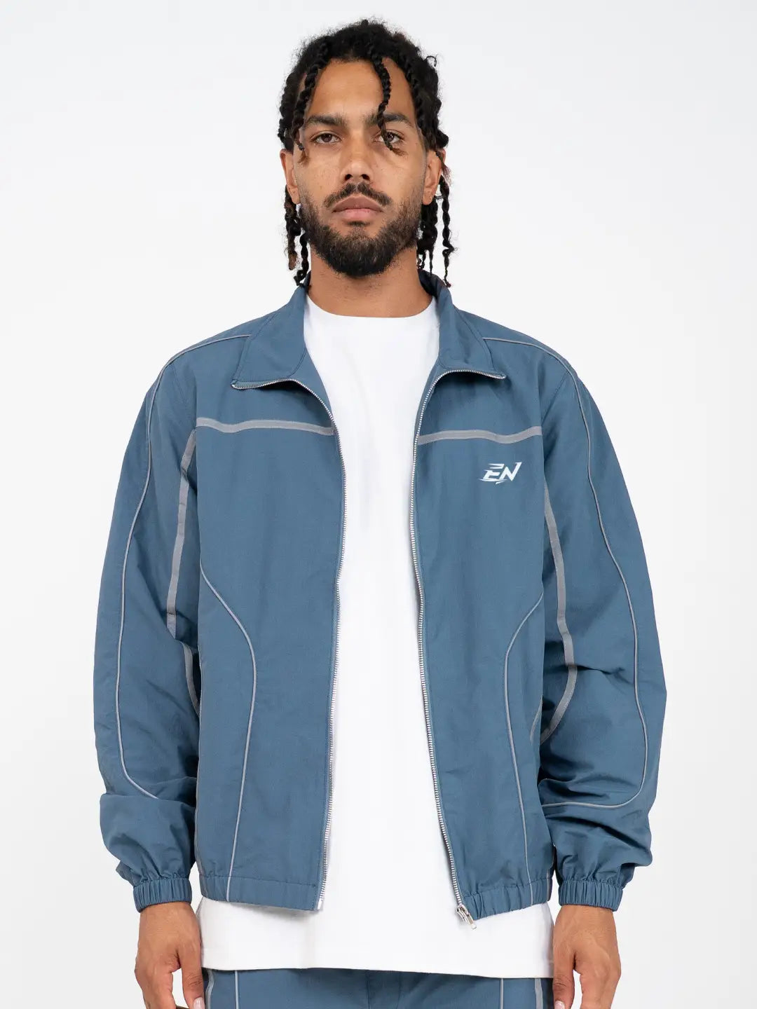 The Blue jacket delivers a structured yet lightweight feel, while the relaxed-fit track pants ensure fluid movement and all-day comfort. 