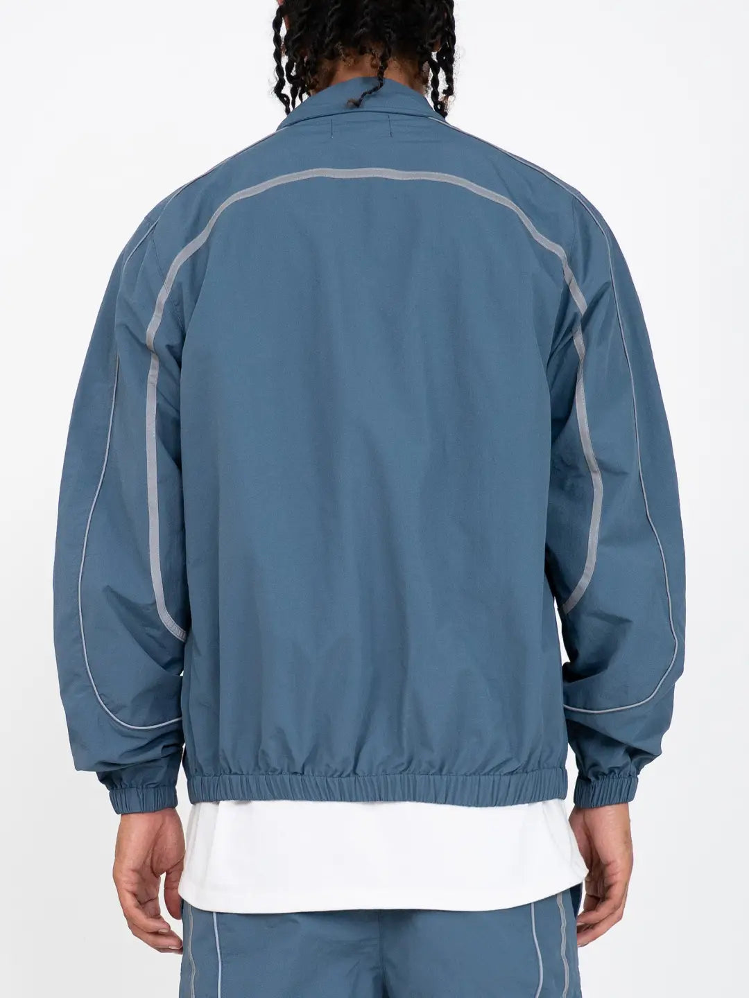 The Blue jacket delivers a structured yet lightweight feel, while the relaxed-fit track pants ensure fluid movement and all-day comfort. 