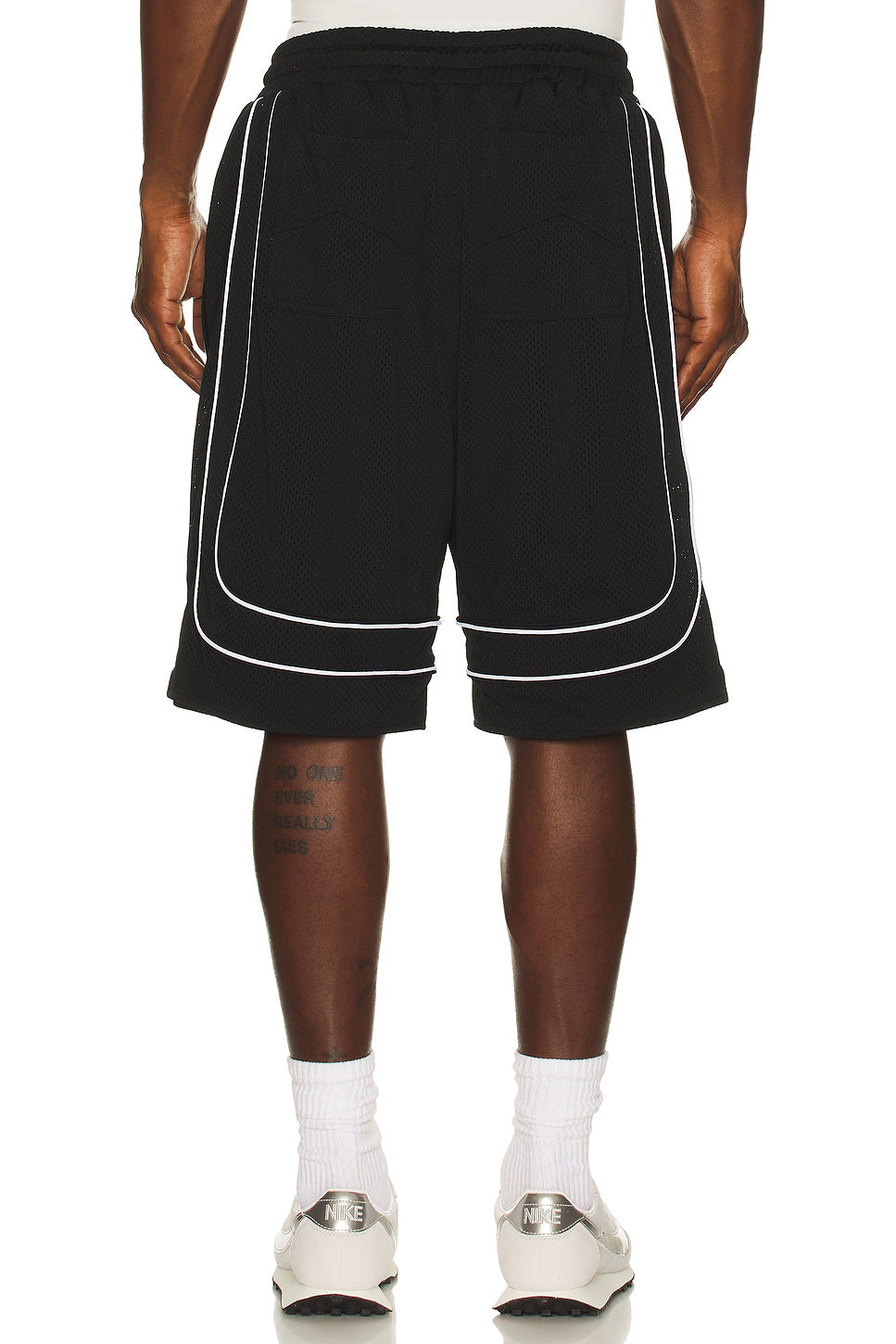 Black shorts with white piping worn by a person on a white background