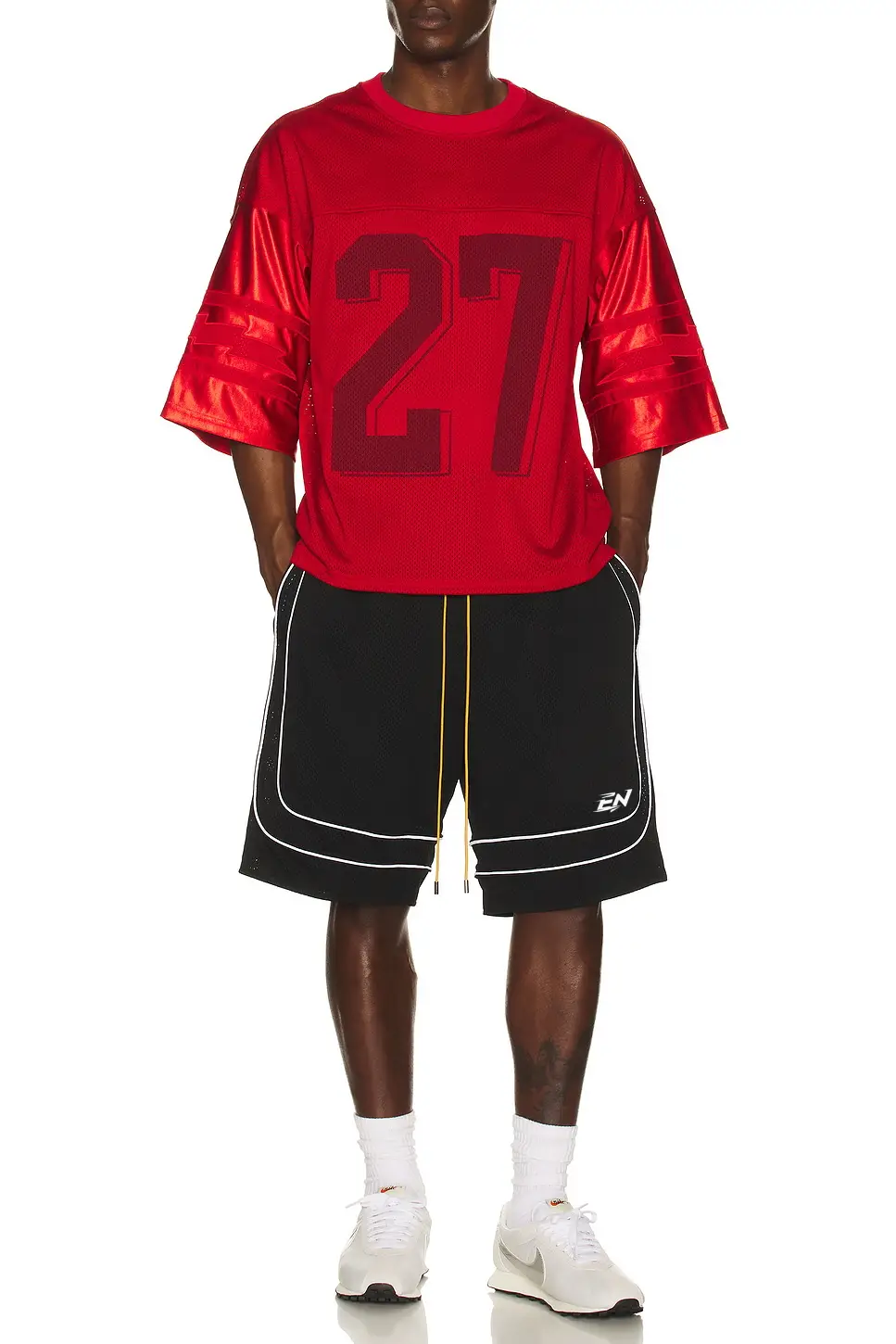 Person wearing a red sports jersey with the number 27 and black shorts on a white background
