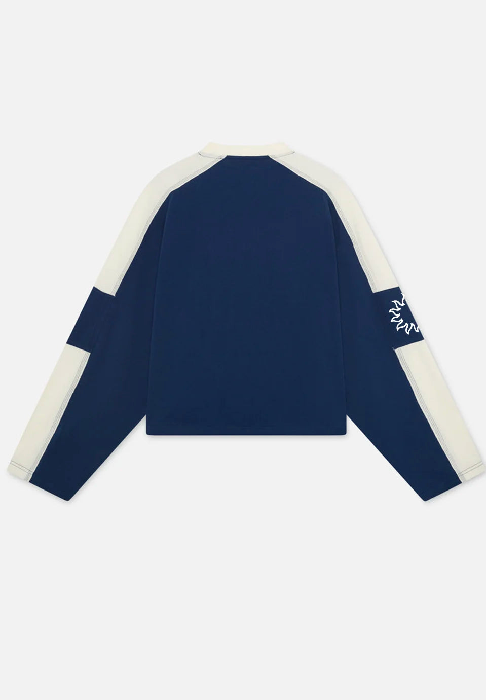 A navy blue long-sleeve top with contrasting cream-colored shoulder and sleeve panels, featuring a white graphic print on the right sleeve.