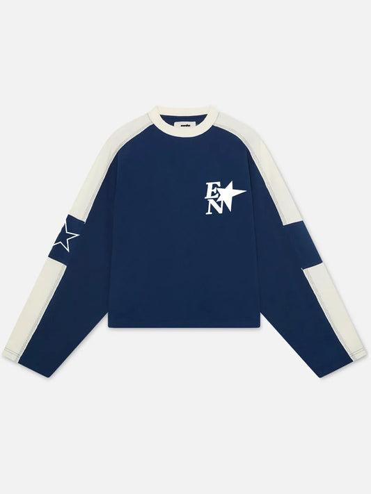 A navy blue long-sleeve crop top sweatshirt with cream-colored raglan sleeves and a white 'EN' star logo on the chest