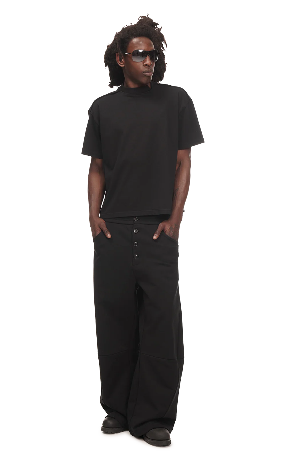 Person wearing a black t-shirt and black pants on a white background