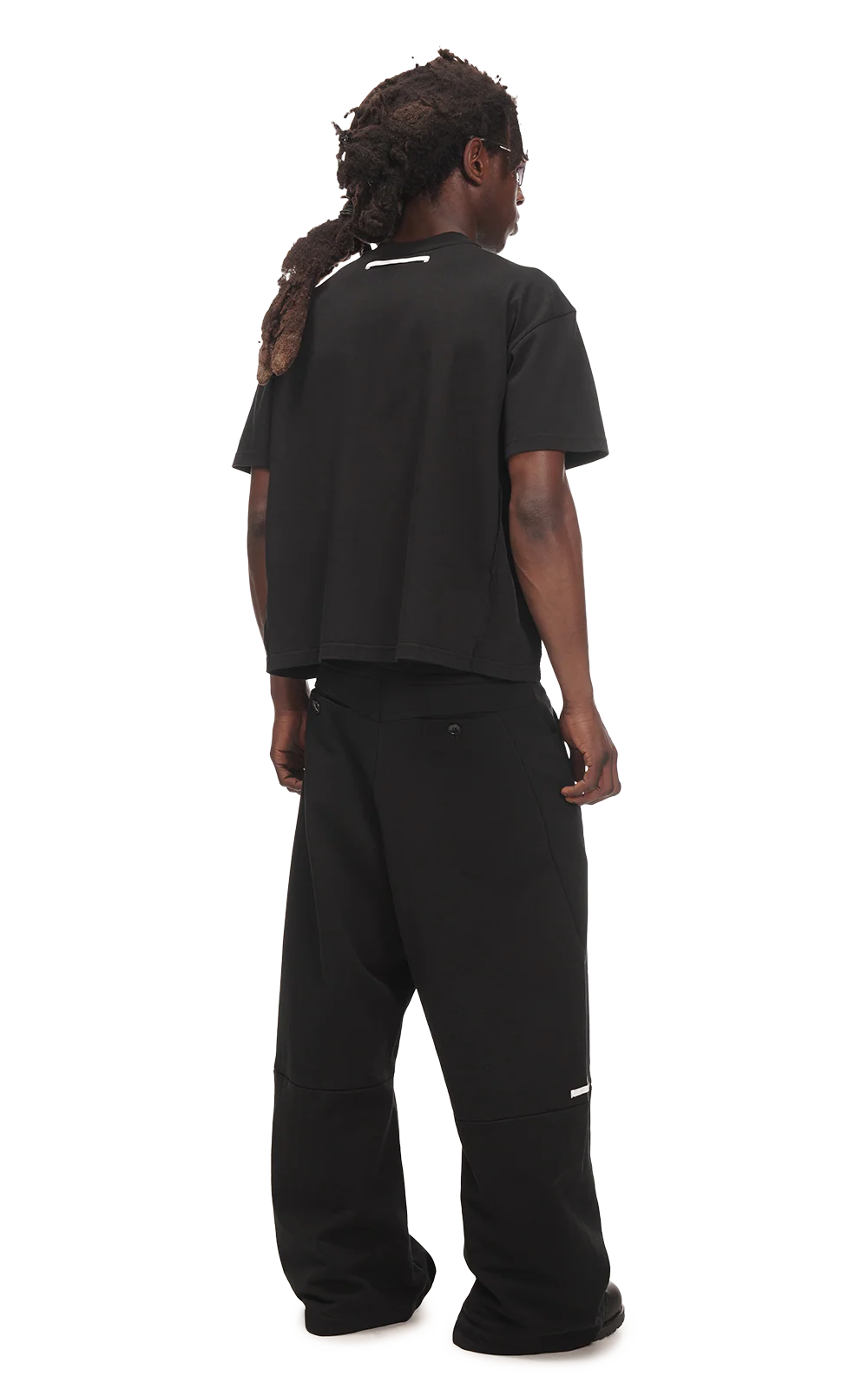 Person wearing a black outfit with reflective accents on a white background