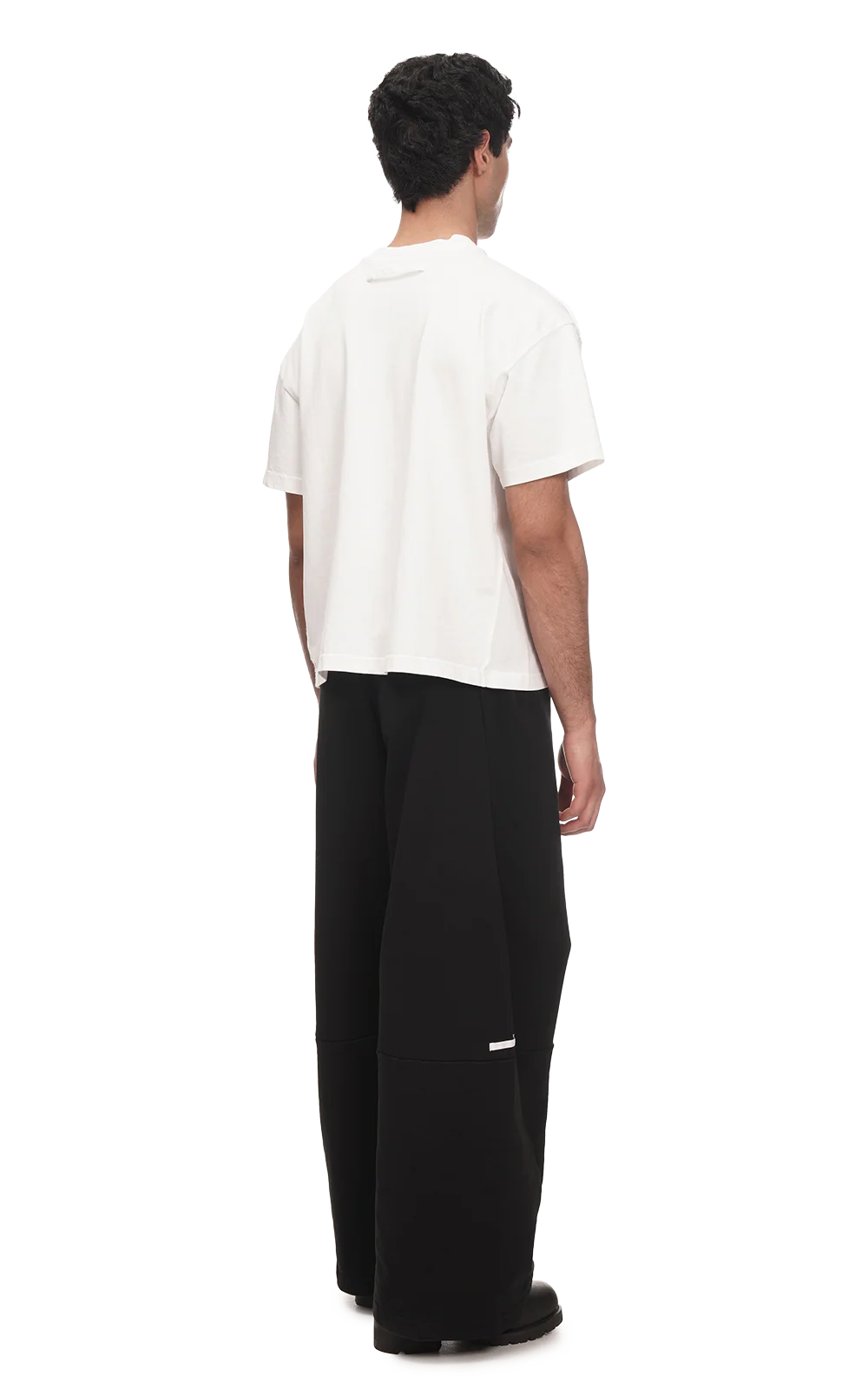 Person wearing a white shirt and black pants on a white background
