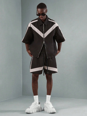 Person wearing a black and white outfit with a grey background